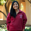 Smiling student wearing red quarter zip with Stanford "S" logo surrounded by white lettering reading "Stanford Cardinal"